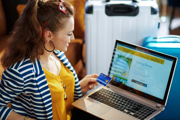 Leende snygg kvinna med kreditkort bokning hotell på laptop — Stockfoto