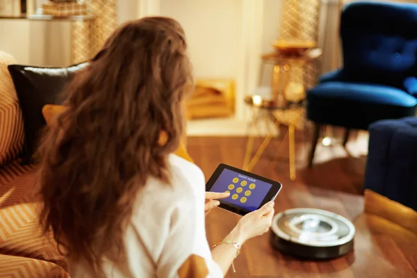 Vrouw met behulp van slimme huis toepassing op tablet Pc en robot vacuüm — Stockfoto