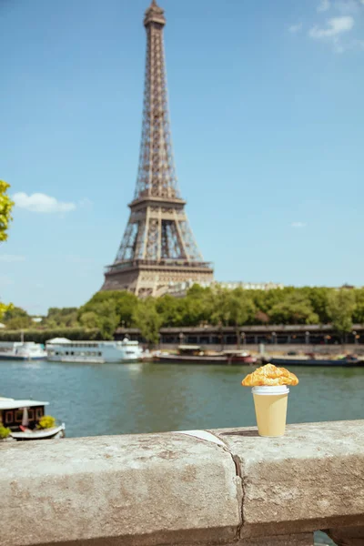 Cup of coffee and croissant on the parapet against Eiffel tower — Stock Photo, Image