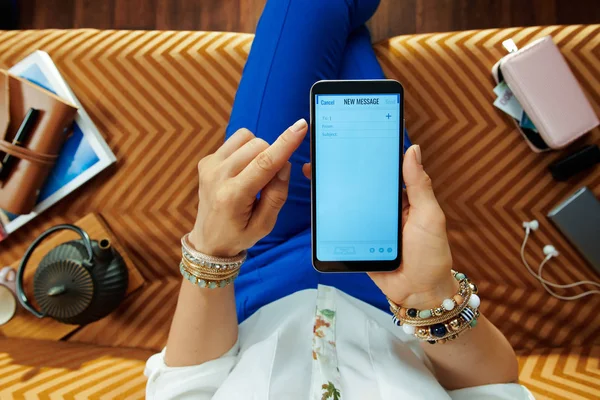 Vrouw zittend op de Bank in moderne woonkamer schrijven e-mail — Stockfoto