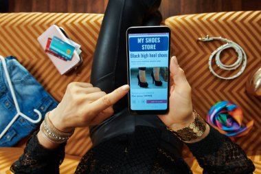 modern oturma odasında kanepede oturan kadın online ayakkabı satın alma