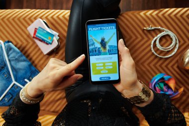 modern oturma odasında kanepede oturan ev hanımı bilet rezervasyon