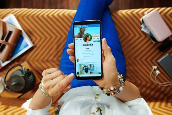 Jonge huisvrouw het controleren van sociale media op smartphone — Stockfoto