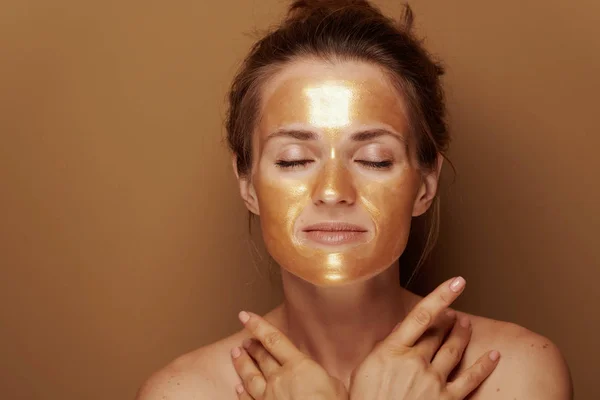 Portret Van Ontspannen Jonge Huisvrouw Met Gouden Cosmetische Gezichtsmasker Bronzen — Stockfoto