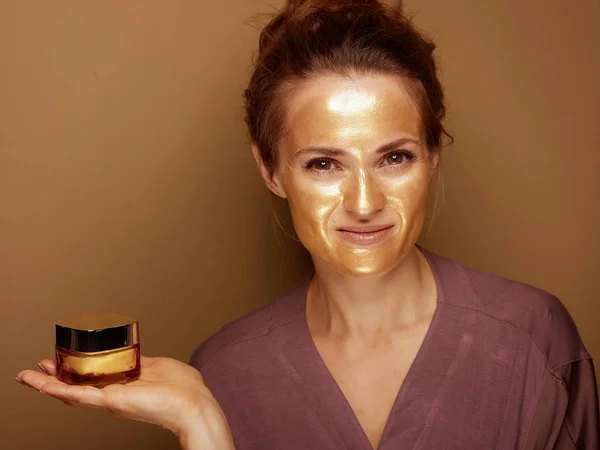 Portret Van Glimlachend Moderne Vrouw Met Gouden Cosmetische Gezichtsmasker Tonen — Stockfoto