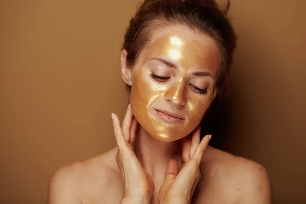 Bej Arka Plan Karşı Altın Kozmetik Yüz Maskesi Ile Rahat — Stok fotoğraf