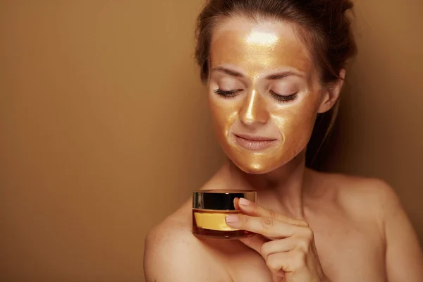 Porträtt Elegant Hemmafru Med Gyllene Kosmetisk Ansiktsmask Som Tittar Flaska — Stockfoto
