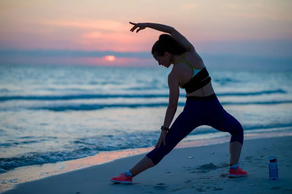 Gesunde Frau am Strand beim abendlichen Stretching — Stockfoto