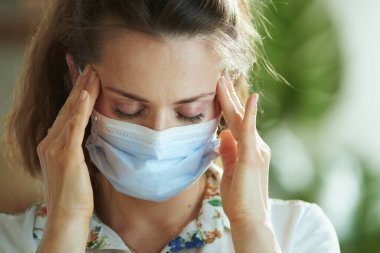 Koronavirüs salgını sırasında hayat. Medikal maskeli, beyaz bluzlu modern kadın portresi..