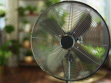 Yaz sıcağı. Modern metalik zemin, güneşli yaz gününde modern evde elektrikli vantilatör..