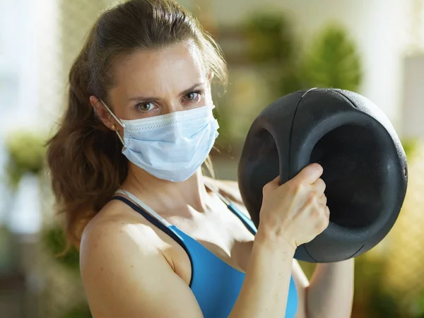 コロナウイルスのパンデミックの間の生活 40歳の健康な女性デュアルグリップ薬ボールトレーニングとフィットネス服 — ストック写真