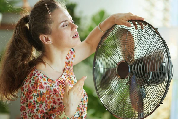 夏天的炎热 在阳光明媚的夏日 穿着花衣的年轻女子在现代住宅里感受着夏日的炎热 — 图库照片