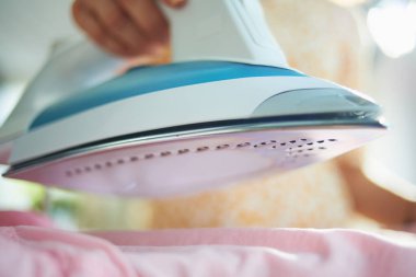 Güneşli bir günde evde demirli bir kadına yakın çekim..