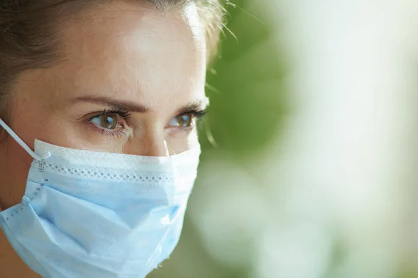 コロナウイルスのパンデミックの間の生活 サイドビューの百合のスタイリッシュな女性で白いブラウスとともに医療マスク — ストック写真