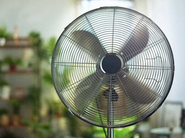 Summer heat. modern metallic floor stand electric fan in the modern house in sunny hot summer day.