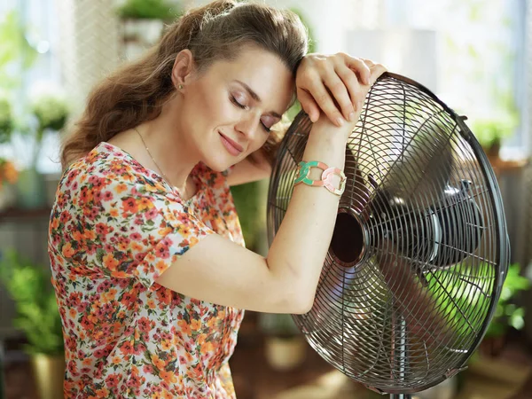 夏天的炎热 在阳光明媚的夏日 穿着花衣的现代女性在现代化的房子里悠闲自在地张开嘴 — 图库照片