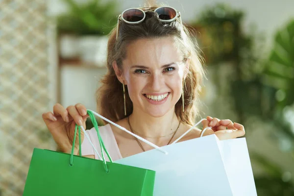 幸せな現代女性の肖像紙のショッピングバッグとサングラスで買い物客 — ストック写真