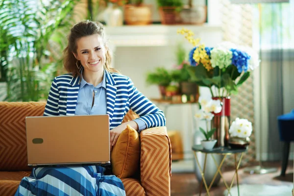 블라우스와 줄무늬 재킷을 여성이 집에서 노트북을 — 스톡 사진