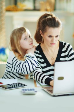 Annesi güneşli bir günde modern evde ev işleriyle meşgulken, sıkılmış bir çocuk ilgi görmek istiyor..