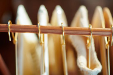 Askıda giysiler olan modern bakır elbise raflarının üst görüntüsü..