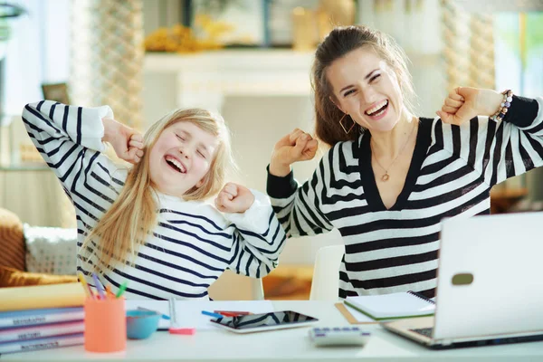 若い母親と娘を笑顔で縞模様のセーターで自宅で現代の家で晴れた日にストレッチ — ストック写真