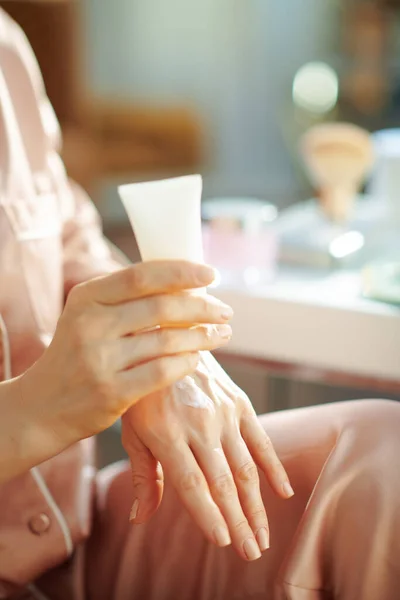 Close Mulher Pijama Com Tubo Cosmético Branco Aplicando Creme Mão — Fotografia de Stock