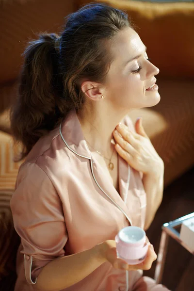 Mujer Relajada Elegante Pijama Con Frasco Cosmético Rosa Aplicando Crema — Foto de Stock