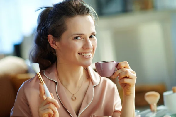 Sonriente Mujer Moderna Pijama Con Cepillo Maquillaje Blanco Bebiendo Café — Foto de Stock