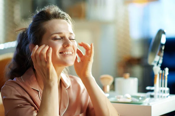 Gelukkige Stijlvolle Vrouw Pyjama Aanbrengen Gezichtscrème Het Maken Van Massage — Stockfoto