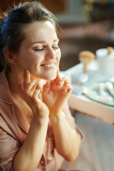 Felice Casalinga Mezza Età Pigiama Applicare Crema Viso Vicino Tavolo — Foto Stock