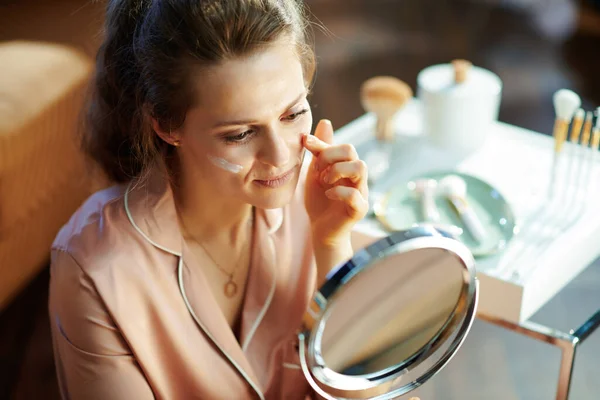 Elegante Casalinga Sorridente Pigiama Che Applica Crema Viso Guarda Allo — Foto Stock