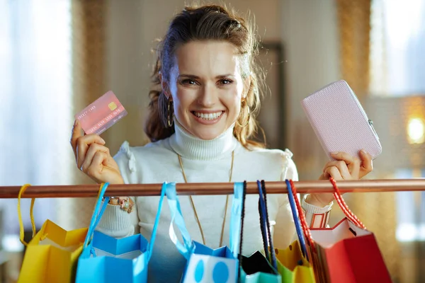 스웨터를 치마를 카드와 지갑을 여성이 옷가지에 쇼핑백 근처에서 — 스톡 사진