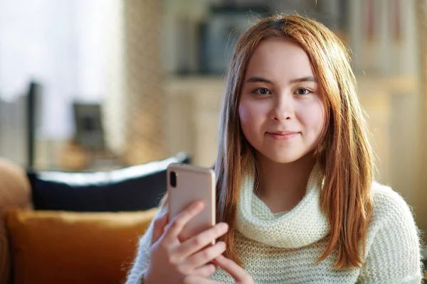 Portret Szczęśliwej Nowoczesnej Nastolatki Białym Swetrze Smartfonem Komunikującej Się Mediach — Zdjęcie stockowe