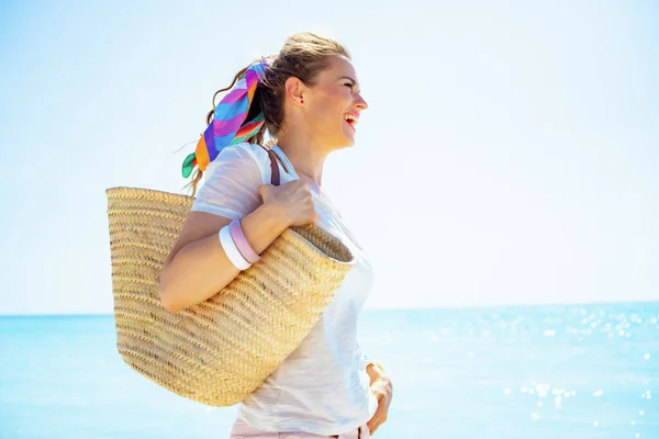 Plaj Çantalı Beyaz Tişörtlü Mutlu Genç Kadın Okyanus Kıyısındaki Mesafeye — Stok fotoğraf