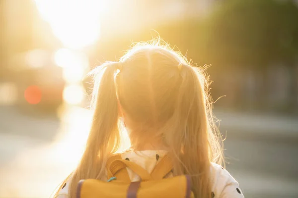 コロナウイルスのパンデミックの間の生活 外の学校に行く黄色のバックパックを持つ女子高生から見た — ストック写真