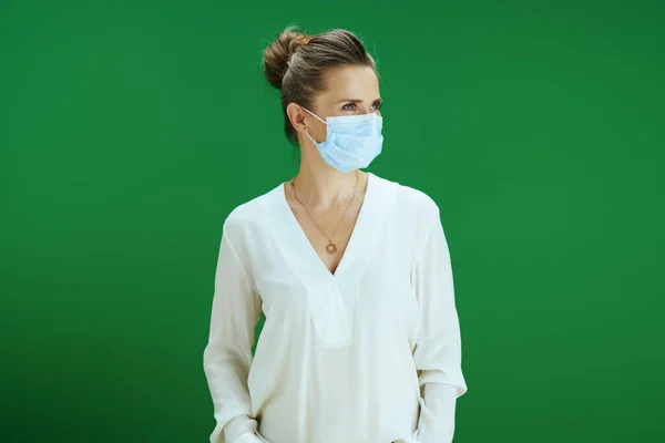 在大肠病毒大流行期间的生命 现代女教师 身穿白衬衫 戴着医疗面罩 衬托着黑板绿色背景 — 图库照片