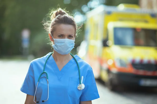验尸官大流行病 救护车外穿着制服 戴听诊器 戴口罩的现代女医生的画像 — 图库照片
