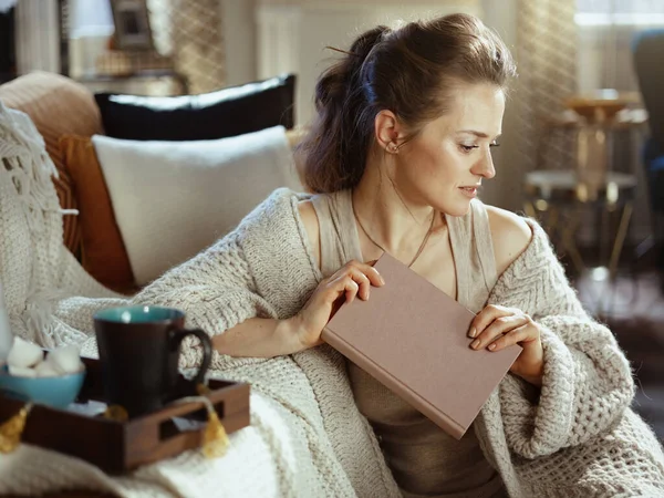 Pensive Moderne Vrouw Gebreid Gezellig Vest Met Boek Dienblad Mok — Stockfoto