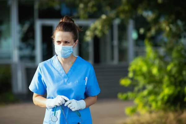 코로나 바이러스 대유행 진료소 근처에서 청진기와 의료용 마스크를 수술복을 서글픈 — 스톡 사진