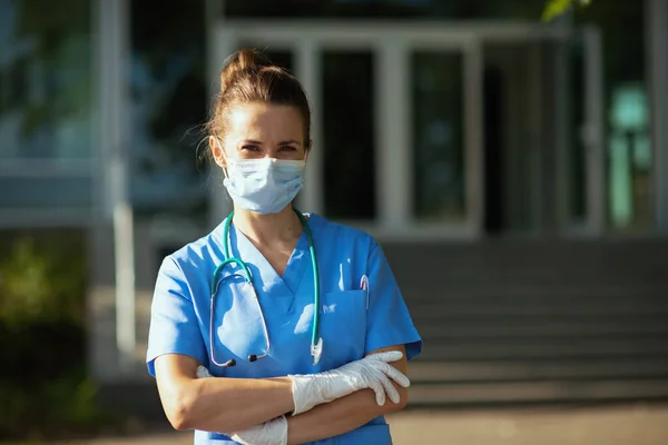 Covid 19大流行病 医院外身穿制服 戴听诊器 戴口罩的自信现代女医生的画像 — 图库照片