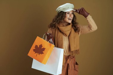 Merhaba Ekim. Mutlu modaya uygun 40 yaşında, deri eldivenli ve bej renkli alışveriş çantalı bir kadın..