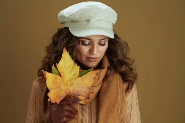 革の手袋と黄色の秋のカエデの葉とスカーフで夢のような流行の女性ベージュの背景に対して — ストック写真
