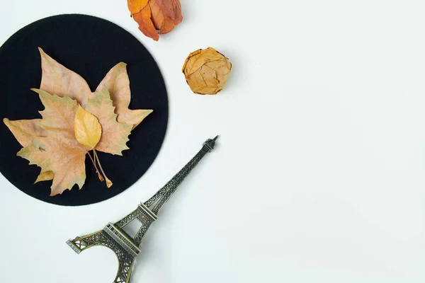 Hello autumn. autumn background with leaves, eiffel tower travel souvenir and beret on white background.
