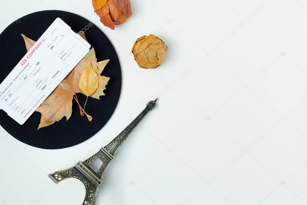 Hello october. autumn background with leaves, air tickets, eiffel tower travel souvenir and beret on white background.