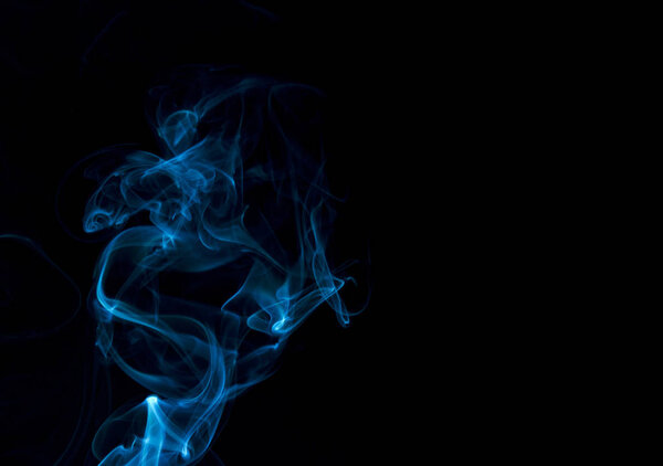 Blue smoke on black background with copy space