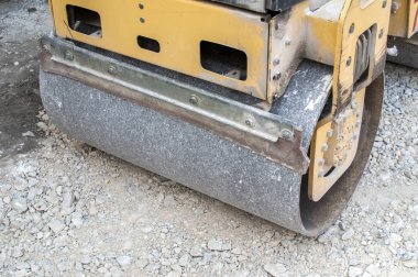 Yol yapımı için şehir sokak çakıl temel düzenleme çalışan küçük yol silindiri detay
