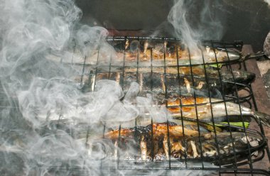 Kırsal ev şömine closeup beyaz duman ile demir tepside Uskumru balığı ızgara