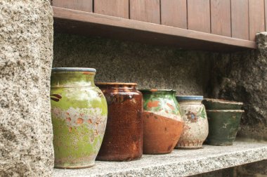 Taş niş ev bahçe duvarı üzerinde bir satırda yan yana çeşitli Seramik kaplar