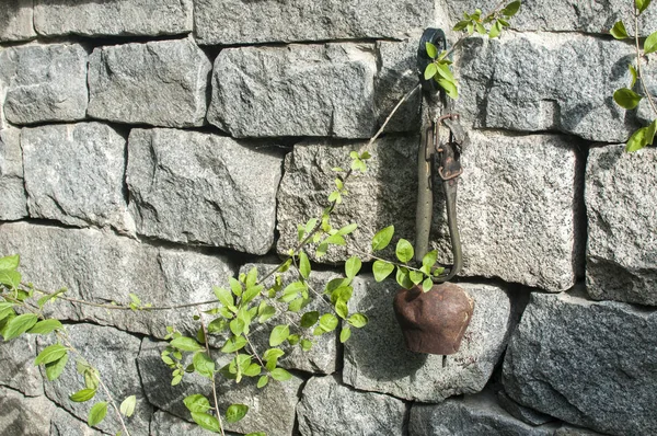 Old Used Weathered Grunge Cowbell Hanging Solid Stone Wall Closeup — Stock Photo, Image
