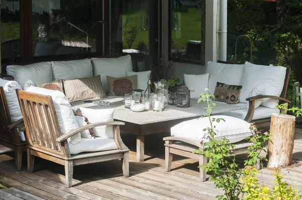 Gartenmöbel Aus Holz Mit Tisch Stühlen Und Kissen Auf Holzdielen lizenzfreie Stockfotos